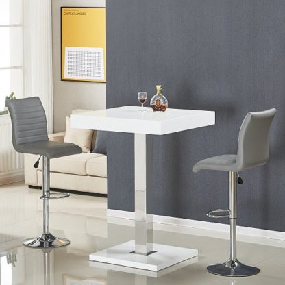 2d118adc0bee0efb463b896d773f8dea53e8988cb79fc00320f6d1b83d0d2234.jpg An Image of Topaz Bar Table In White Gloss With 2 Ripple Grey Stools