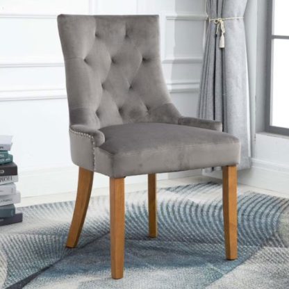 bc877aac2235e61814f7058a7fed9ad154ce50db0279dd3b3702c4100b712bd3.jpg An Image of Lauren Velvet Dining Chair In Grey With Oak Legs