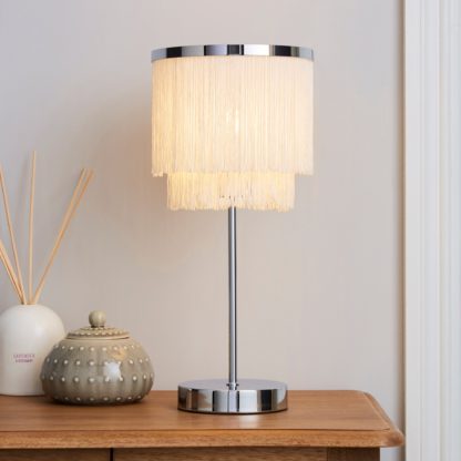 0725bb551934d508d43dff10020ef133003a49e78a52bf3a9a9c1213d359300a.jpg An Image of Jaz Fringe Ivory Table Lamp Cream and Silver