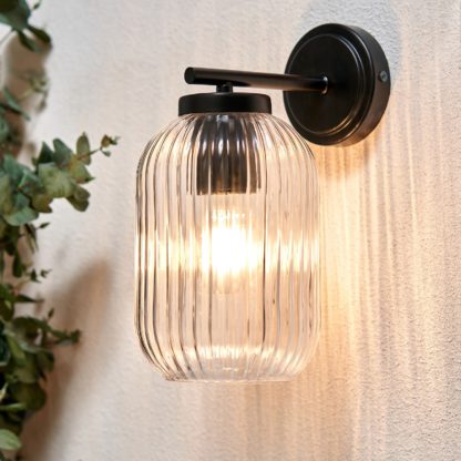 3031b7f8256eb6c3069c88edb564ab43bf6daa86954fd16da995096286b3007a.jpg An Image of Stanton Ribbed Glass Outdoor Wall Light